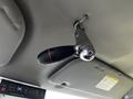 A silver gear shifter with a black grip and red accent is mounted on the ceiling of a 2011 Ford Econoline