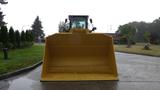 A 2019 Caterpillar 972M XE wheel loader with a large yellow bucket facing forward