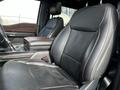 Interior view of a 2021 Ford F-150 showing black leather front seats with a center console and armrest