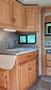 A kitchen area in a 2007 Winnebago Adventure featuring wooden cabinets a sink and a countertop with drawers beneath
