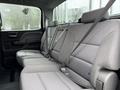 The interior of a 2015 GMC Sierra 1500 featuring a rear bench seat with seatbelts and textured gray upholstery