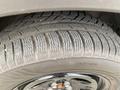 Close-up of a treaded tire on a 2021 Ford Explorer showcasing the intricate design of the rubber and the rim's black finish