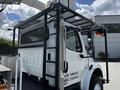 A 2012 Freightliner M2 106 truck with a utility body and a protective mesh rack on the side