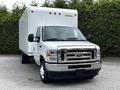 A 2021 Ford E-450 truck with a white box cargo area and a silver grille is parked facing the viewer