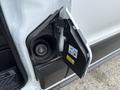 A 2023 Ford Transit gas cap door open revealing the fuel filler neck and warning labels inside