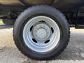 A close-up of a silver wheel from a 2020 Ford F-550 featuring a five-bolt pattern and a black tire with tread visible