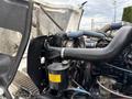 Close-up view of the engine compartment of a 1998 Freightliner FL80 showing the radiator fan and various hoses and components