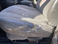A worn driver's seat in a 2012 GMC Savana with visible scratches and a faded design on the side of the seat upholstery