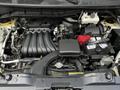 Engine compartment of a 2020 Nissan NV200 with visible components such as the air intake manifold battery and various hoses and wires