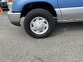 Close-up of a 2009 Ford Econoline's front wheel featuring a silver alloy rim and a rugged tire with noticeable tread pattern