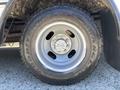 Close-up of a wheel and tire of a 2020 Chevrolet Express featuring a silver steel rim with five bolts and a Goodyear tire with an all-terrain tread pattern
