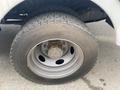 Close-up of a wheel and tire from a 2003 Ford F-450 SD showing the rugged tread pattern and metallic wheel rim