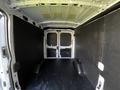 Interior of a 2022 Ford Transit van with two rear doors and black paneling on the walls and floor designed for cargo space