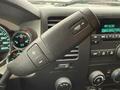Close-up of a steering wheel control in a 2013 Chevrolet Silverado 3500HD featuring buttons for audio and cruise control settings