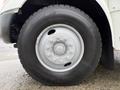 A close-up view of a wheel and tire from a 2016 International CE300 showing a silver multi-bolt hub and a black tread tire