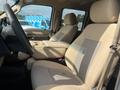 Interior of a 2014 Ford F-350 SD showing two beige front seats with fabric upholstery and a center console