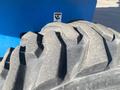 A close-up view of a rugged tire from a 1997 Genie S-65 4X4 showing its deep tread pattern designed for off-road traction
