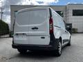 A white 2014 Ford Transit Connect van is parked with its rear view facing the camera showcasing its simple design and dual rear doors