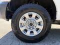 Close-up of a 2014 Ford F-250 SD wheel featuring a silver alloy rim and a large all-terrain tire with a tread pattern designed for off-road performance
