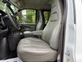Interior of a 2021 Chevrolet Express showing two leather seats in the front cabin with a steering wheel and dashboard visible