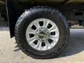 Close-up of a silver alloy wheel with a rugged tire on a 2020 Ford F-350 SD showcasing the brand logo and detailed tread pattern