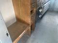Interior view of a 2007 Morgan Olson Workhorse W42 showing a wooden counter and drawers along one side with metal pipes stored along the opposite side