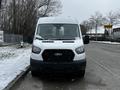 A 2021 Ford Transit van with a white exterior and black grille parked in a snowy environment