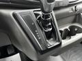 Gear shift console of a 2023 Ford Transit with a black leather cover and gear selection buttons for park reverse neutral drive and manual