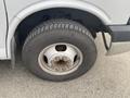 A close-up of a silver wheel on a 2016 Chevrolet Express featuring a tire with visible tread and multiple lug nuts on the wheel rim