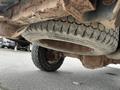 Underside view of a 2010 Ford F-150 showing a worn tire and suspension components