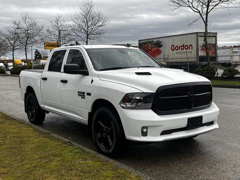 A 2022 RAM 1500 Classic in white with a black grille and black accents parked on a street