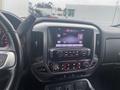 The dashboard of a 2015 GMC Sierra 1500 featuring a large touchscreen display with audio controls and climate settings