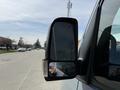 Close-up of the side mirror of a 2019 Mercedes-Benz Sprinter showing the reflection of a hand and the road ahead