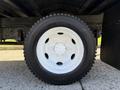 Close-up of a white wheel of a 2007 GMC W5500 18 Foot Cube Van with a black tire mounted on it