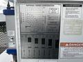 A placard displaying load ratings and operational instructions for a 2008 International 7500 crane model including various charts and warning notices