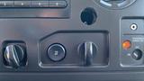 Dashboard controls of a 2013 Ford Econoline including knobs for temperature and air settings and a warning light for the passenger airbag