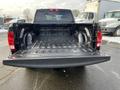 Rear view of a 2015 RAM 1500 pickup truck showing the open truck bed with a black interior and tailgate down