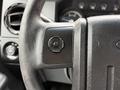 Close-up view of the steering wheel and control panel of a 2013 Ford F-550 featuring buttons and gauges