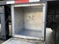 An empty metal storage compartment attached to a 2010 International 4300 truck