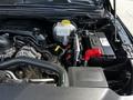 The image shows the engine compartment of a 2019 RAM 1500 featuring an exposed battery and various engine components including hoses and a coolant reservoir