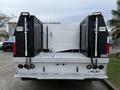 A 2016 Ford F-550 Super Duty with a flatbed and side storage compartments visible from the rear
