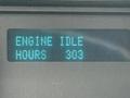 A digital display showing the message ENGINE IDLE HOURS 303 on a dashboard of a vehicle