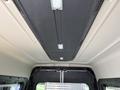 Ceiling interior of a 2021 RAM Promaster showing a smooth surface with lighting and an overhead compartment for storage