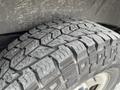 A close-up view of a 2014 GMC Savana tire with a detailed tread pattern showing wear and dirt on its surface