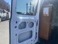 A 2009 Ford Econoline van door with cutouts for windows and hardware, showing its interior panel and structural design