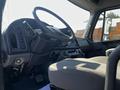 Interior view of a 2004 Freightliner M2 showing the steering wheel dashboard and driver's seat