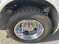 Close-up of a chrome wheel with a large tire mounted on a 2015 Ford F-450 SD showcasing detailed tread patterns and shiny rim