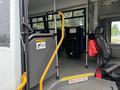 A 2020 Chevrolet Express interior with a side door open showing seating area and safety instructions displayed near the entrance