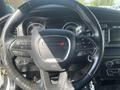 Steering wheel of a 2017 Dodge Charger featuring control buttons and a circular logo in the center