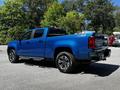 2021 Chevrolet Colorado in bright blue color with a crew cab and chrome accents parked in a lot